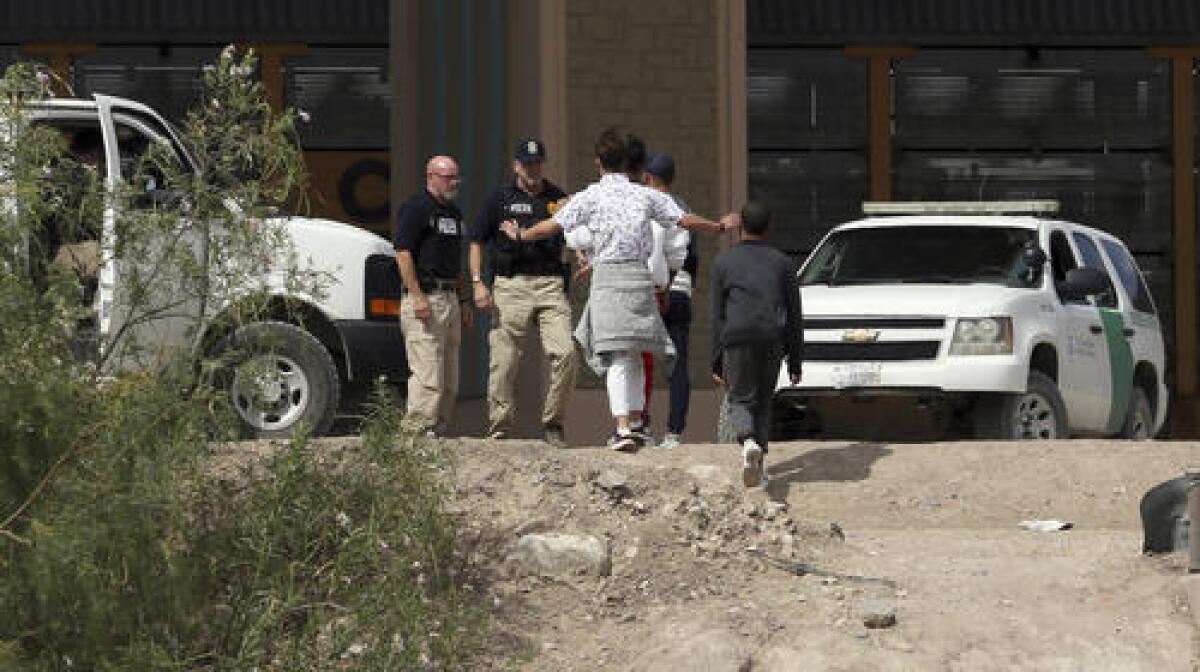 En esta imagen de archivo, tomada el 4 de julio de 2019, un grupo de solicitantes de asilo cruza la frontera entre El Paso, Texas, y Juárez, Chihuahua, México. (Mark Lambie/The El Paso Times via AP)