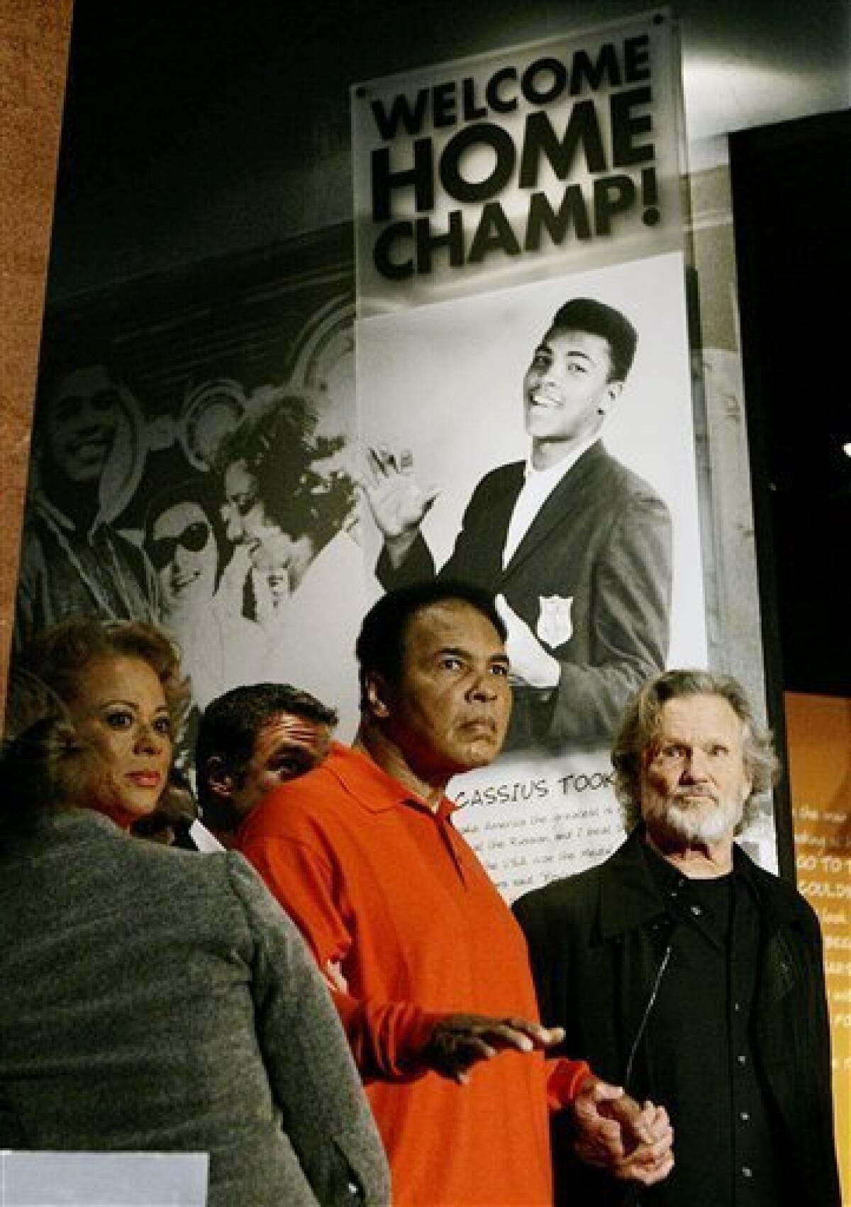FILE - In this Nov. 18, 2005 file photo, boxing great Muhammad Ali is accompanied by his wife Lonnie and singer Kris Kristofferson as he tours the Muhammad Ali Center in Louisville, Ky. The man who became the world's most recognizable athlete was a baby sitter, a jokester and a dreamer in the predominantly black West End neighborhood of Louisville where he grew up and forged lasting friendships while beginning his ascent toward greatness. Now, as the iconic boxer slowed by Parkinson's disease prepares to turn 70 next week, he's coming home for a birthday bash at the downtown cultural center and museum that bears his name. (AP Photo/Ed Reinke, File)