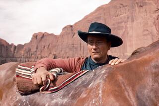 In this photo released by Warner Bros., actor John Wayne plays Ethan Edwards in the newly remastered and restored special edition DVD of The Searchers. Director John Ford and frequent leading man Wayne forged one of Hollywood's most enduring partnerships. Ford and Wayne rode again at the 59th International film festival in Cannes, which featured a documentary about their collaboration. (AP Photo/Warner Bros.)