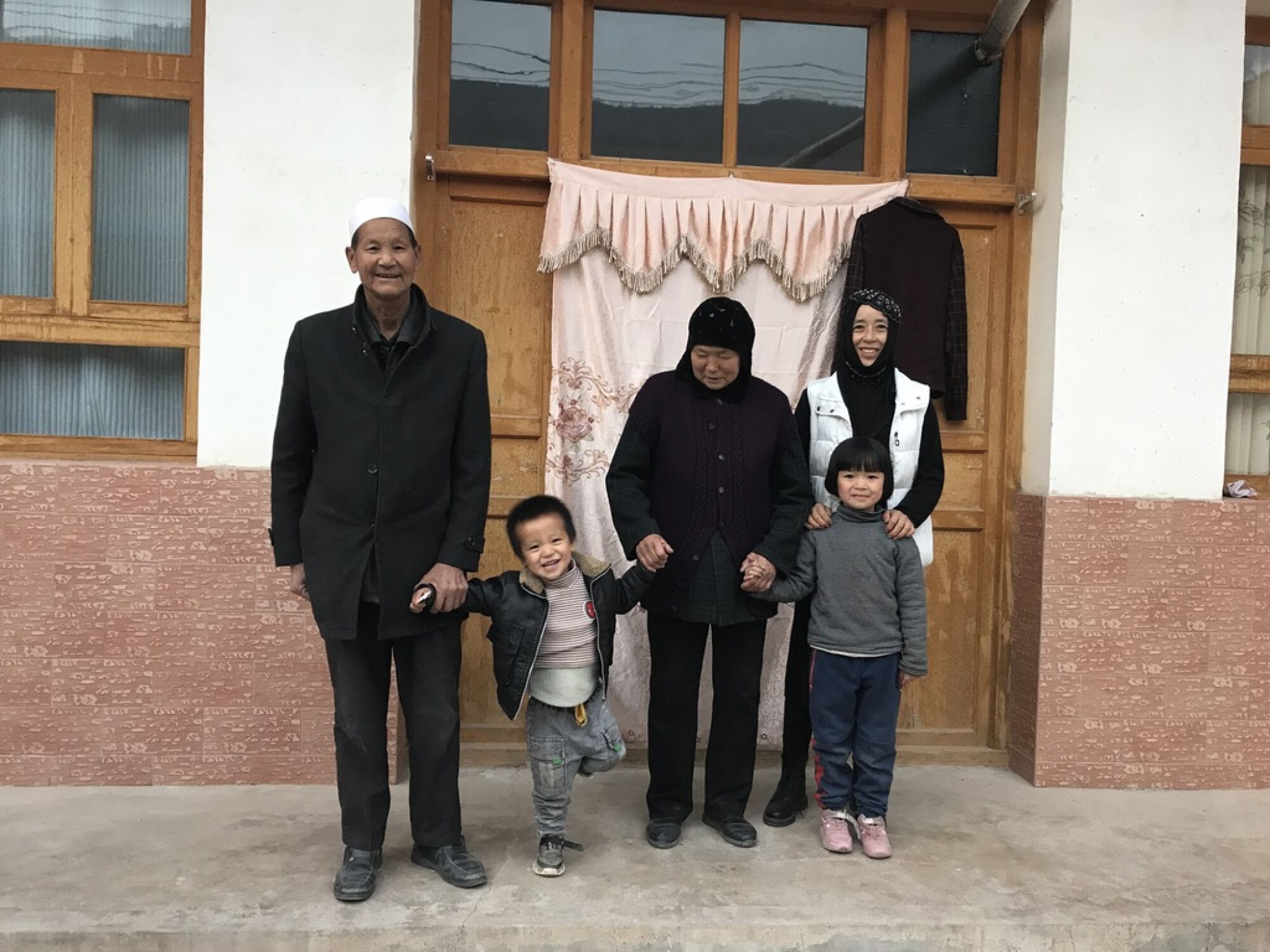 Mawumaile and Maruru, a Dongxiang couple in Bulengou village, pose with their daughter-in-law and two grandchildren.
