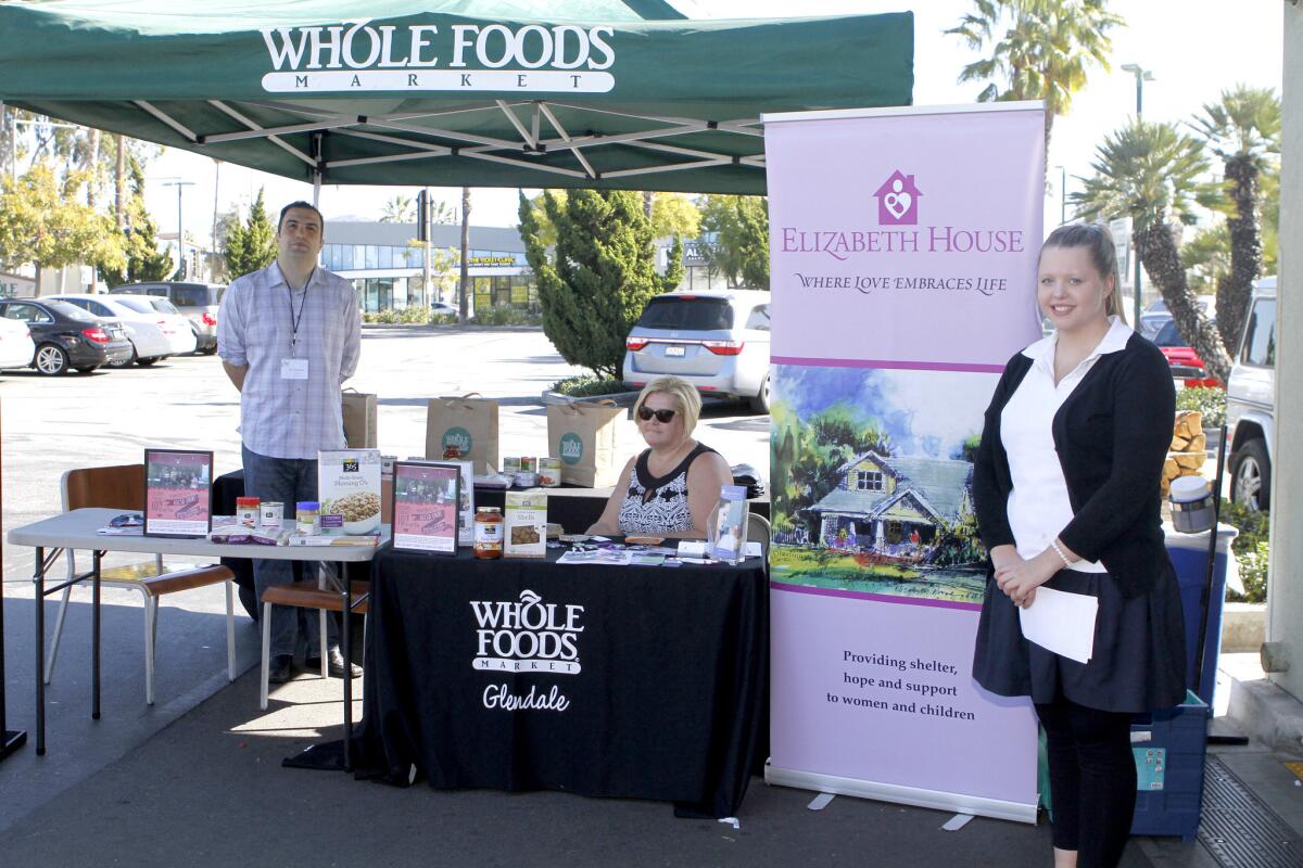 K12 and Elizabeth House volunteers, l-r, Gary Gyultemiruan, Gretchen Dreyer and Lydia Dreyer help collect non-perishable goods a food drive for the women's shelter at Whole Foods in Glendale on Tuesday, Feb. 10, 2015. Elizabeth House is a homeless shelter for pregnant women in Pasadena.