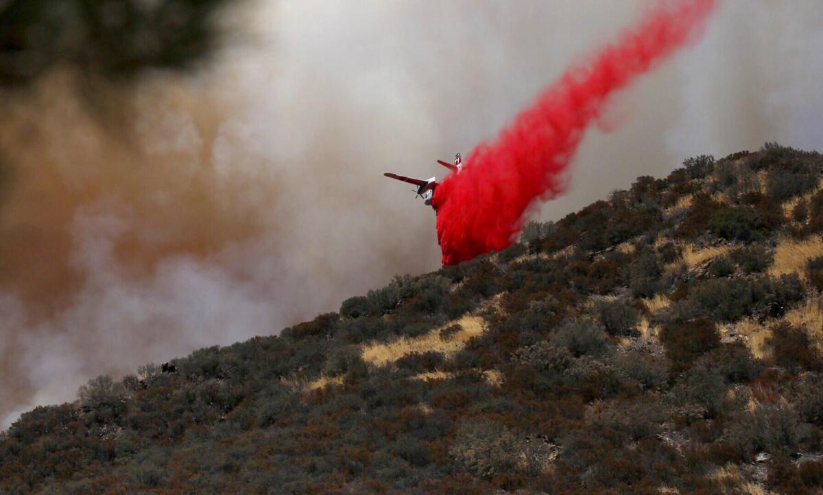 A plane drops fire retardant on the Blue Cut fire that broke out late Tuesday morning in the Cajon Pass.