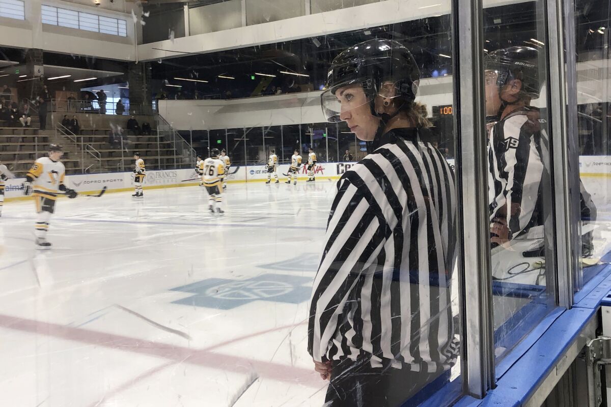 FILE - In this Sept. 6, 2019, file photo, linesman Kirsten Welsh watches at center ice as Pittsburgh Penguins and Boston Bruins players take the ice to prepare to play in the Sabres prospects hockey tournament in Buffalo, N.Y. Ten female officials will work games in the American Hockey League this season. Katie Guay, fellow referees Kelly Cooke, Jacqueline Zee Howard, Laura White, Samantha Hiller, Elizabeth Mantha and Amanda Tasson and linespeople Kendall Hanley, Welsh and Alexandra Clarke are part of 17 new AHL officials. (AP Photo/John Wawrow, File)