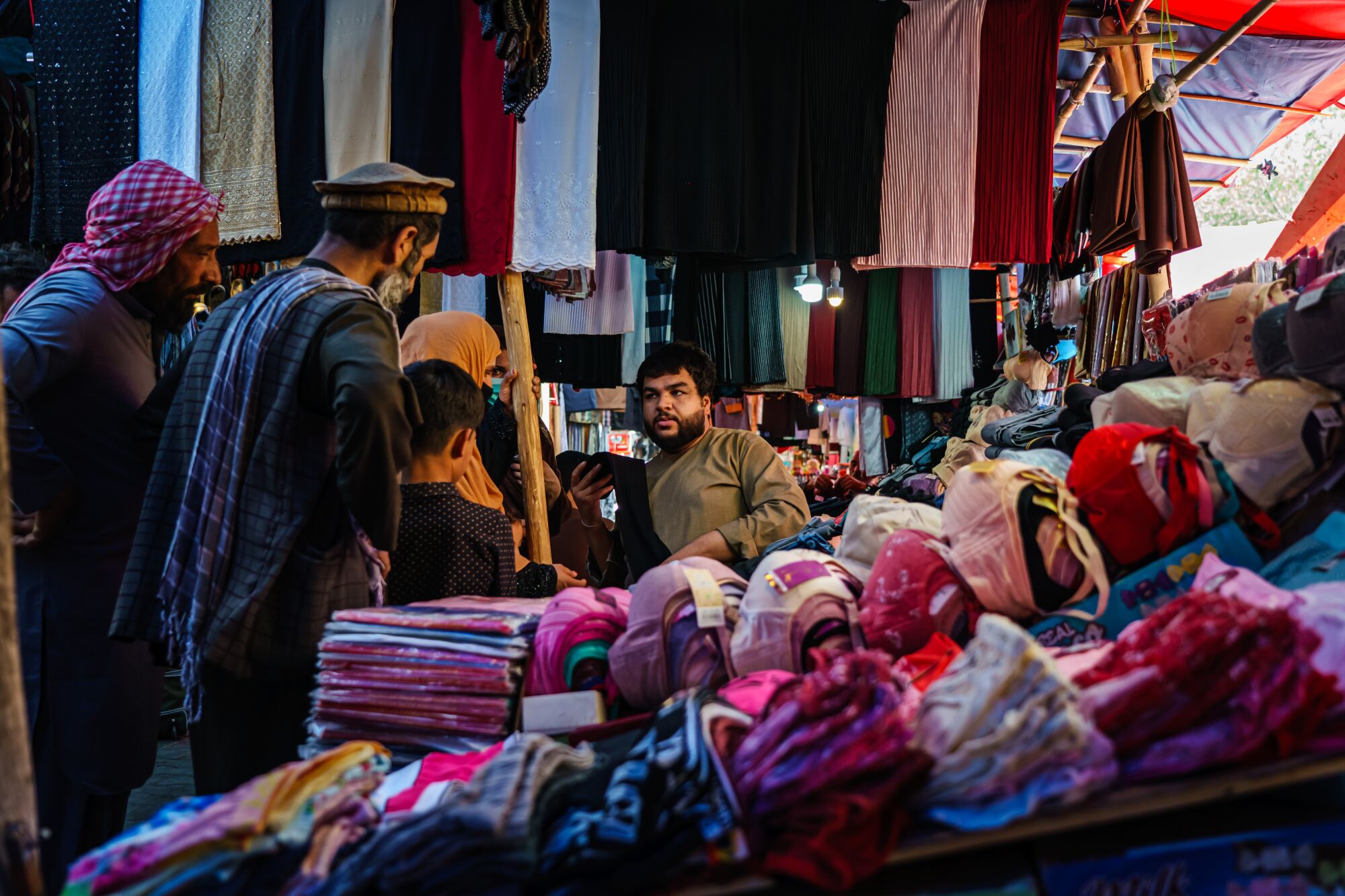 A shopkeeper talks to female and male customers