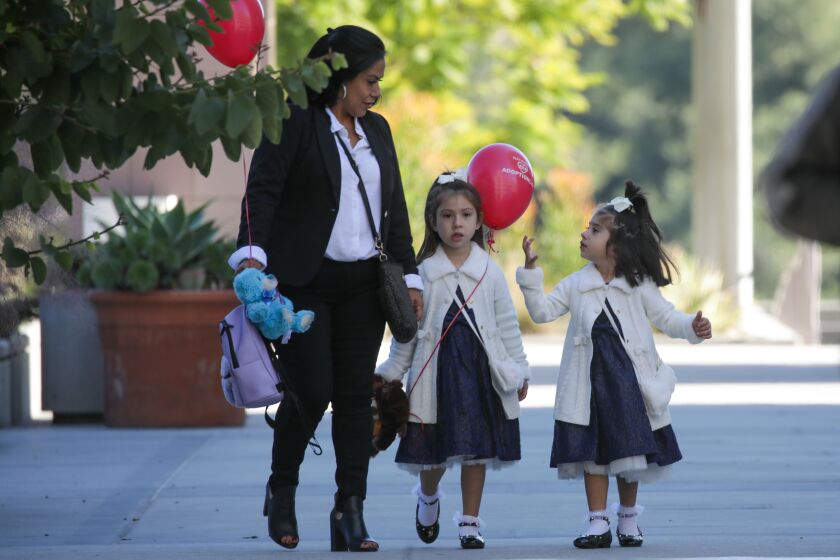 Monterey Park, CA - November 19: Yvette Garay, left, with here two nieces Angel 4, Mariah, 2, after adopting them at a ceremony held at Edmund D. Edelman Children's Court on Saturday, Nov. 19, 2022 in Monterey Park, CA. (Irfan Khan / Los Angeles Times)