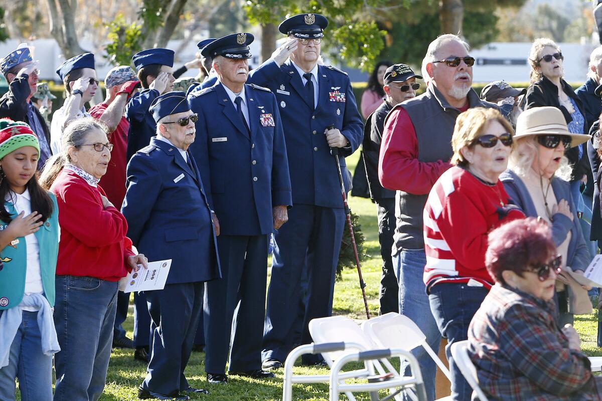 Maj. Jeff Goeggel, center, salutes during the Pledge of Allegiance on National Wreaths Across America Day. 