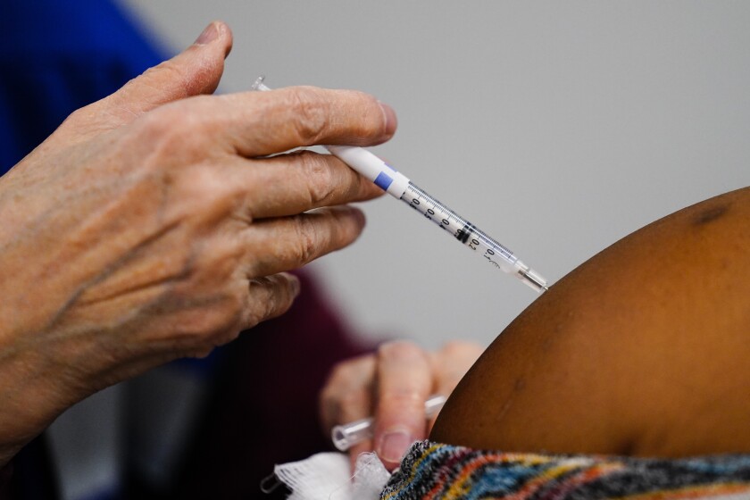 A health worker administers a dose of a COVID-19 vaccine during a vaccination clinic at the Keystone First Wellness Center in Chester, Pa., Wednesday, Dec. 15, 2021. (AP Photo/Matt Rourke)