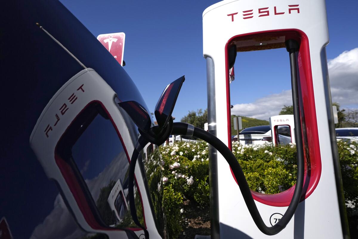 A Tesla electric vehicle is plugged in at a Supercharger station in Westlake on May 10. 