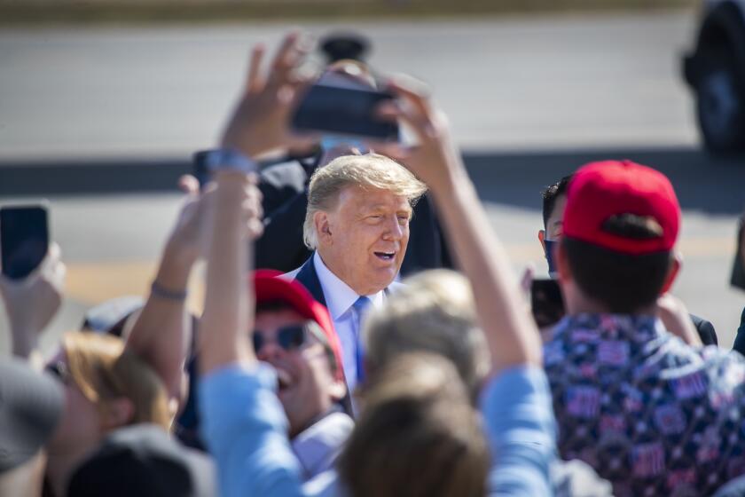 SANTA ANA, CA - OCTOBER 18: President Donald Trump greets supporters as he arrives on Air Force One at John Wayne Airport on Sunday, Oct. 18, 2020 in Santa Ana, where he will be attending a fundraiser at the home of Palmer Luckey on Lido Island in Newport Beach. (Allen J. Schaben / Los Angeles Times)