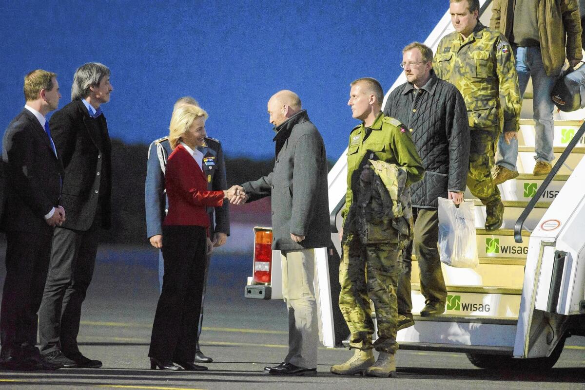 At Berlin's Tegel Airport, German Defense Minister Ursula von der Leyen greets freed observer Axel Schneider and other members of the OSCE team on May 3, 2014, after their release from captivity in eastern Ukraine.