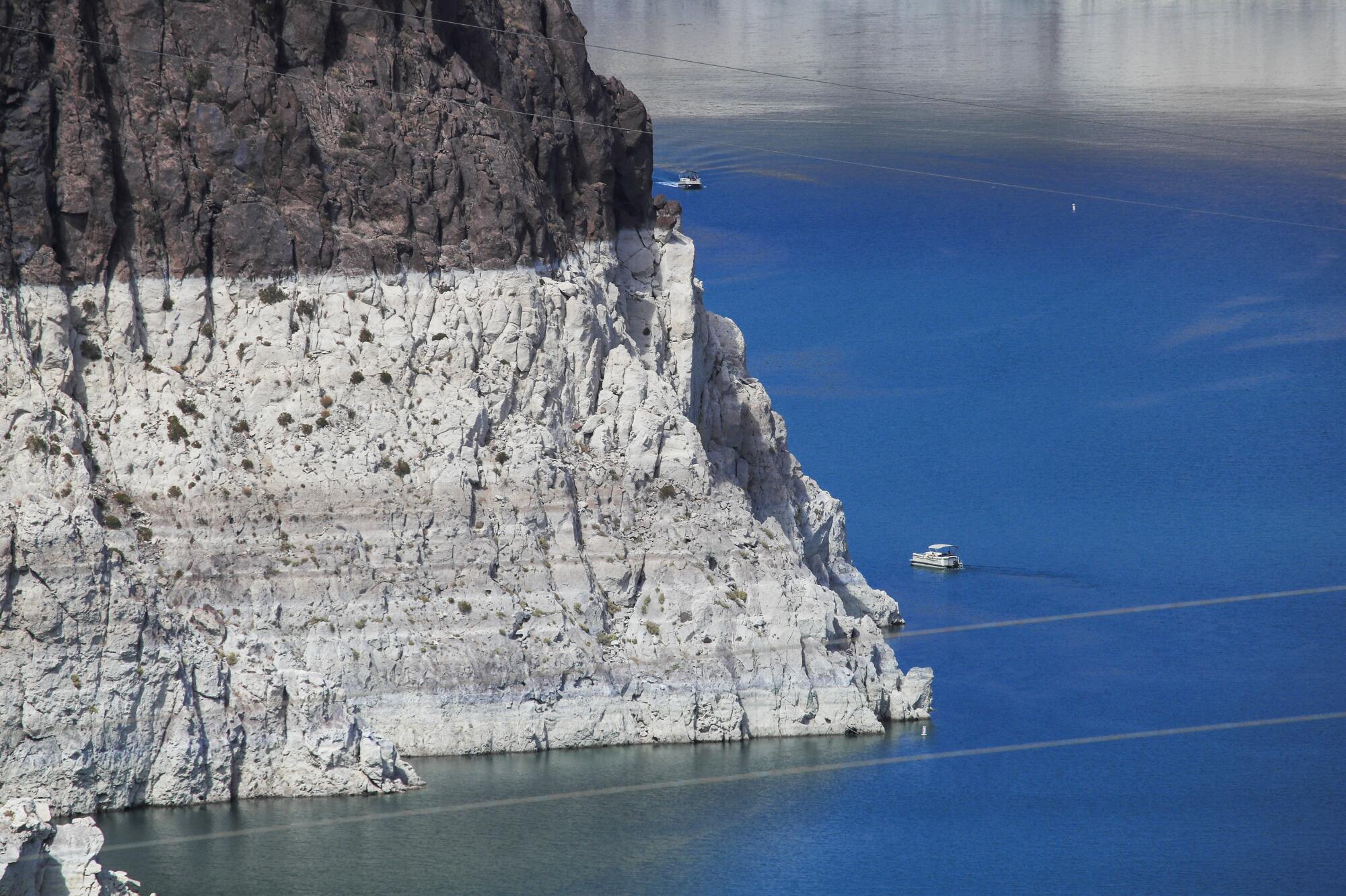 A boater gets an up-close view of previously submerged surfaces at Lake Mead.