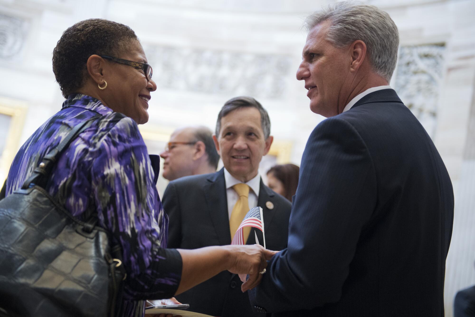 Karen Bass and Kevin McCarthy speak as Dennis Kucinich looks on