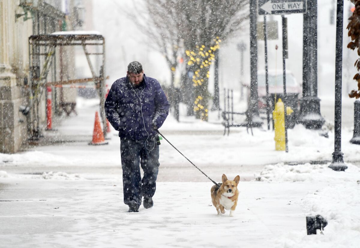 Ryan Cummins camina con su perro en una calle de Pittsfield, Massachusetts