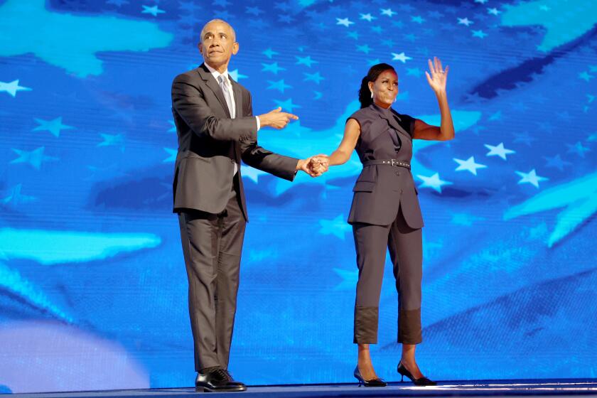 DNC CHICAGO, IL AUGUST 20, 2024 - Former President Barack Obama, left, points to his wife former first lady Michelle Obama after she introduces him on stage during the Democratic National Convention Tuesday, Aug. 20, 2024, in Chicago. (Robert Gauthier/Los Angeles Times)