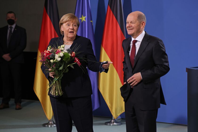 BERLIN, GERMANY - DECEMBER 08: New German Chancellor Olaf Scholz (R) and former German Chancellor Angela Merkel pose for a photo during the official transfer of office at the Chancellery on December 08, 2021 in Berlin, Germany. Olaf Scholz will lead a three-party federal coalition government comprised of the German Social Democrats (SPD), the Greens Party and the German Free Democrats (FDP), officially succeeding the previous government of Angela Merkel. (Photo by Sean Gallup/Getty Images)