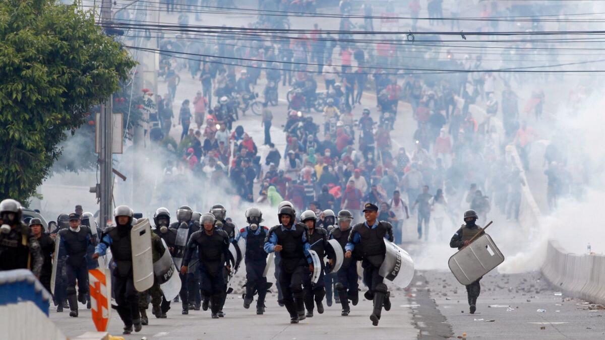 Police run away from supporters of opposition presidential candidate Salvador Nasralla after firing their last tear gas canisters at the demonstrators in Tegucigalpa, Honduras.