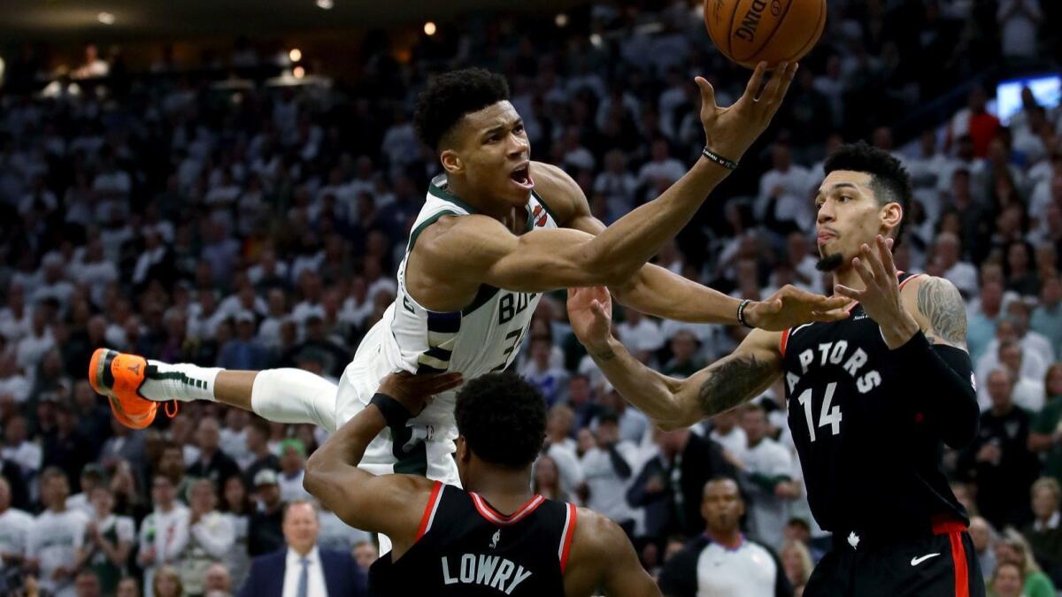 Raptors guard Kyle Lowry tries to draw a charge against Bucks forward Giannis Antetokounmpo during Game 1.