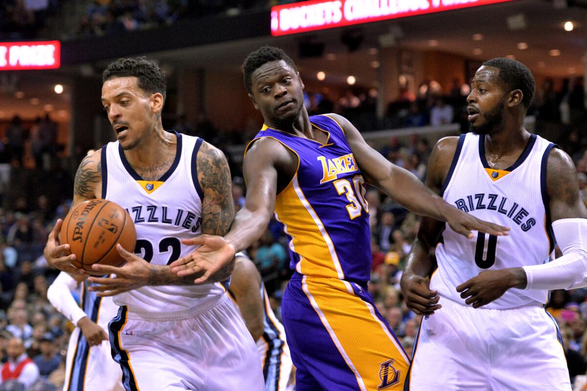 Grizzlies forward Matt Barnes, left, works to control the ball against Lakers forward Julius Randle (30) during the first half of a game on Feb. 24 as forward JaMychal Green looks on.
