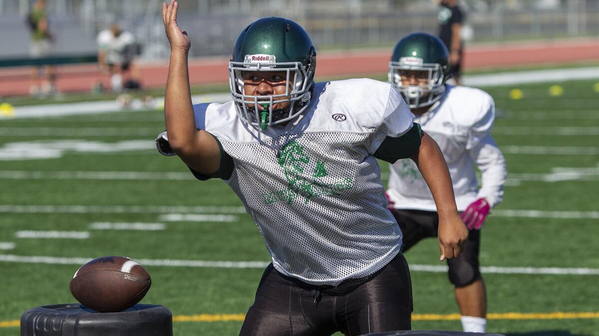 Costa Mesa High's Carlos Aguilar works on a line drill during practice on Aug. 14. The Mustangs play Calvary Chapel on Thursday as both teams try to win their first Orange Coast League game.