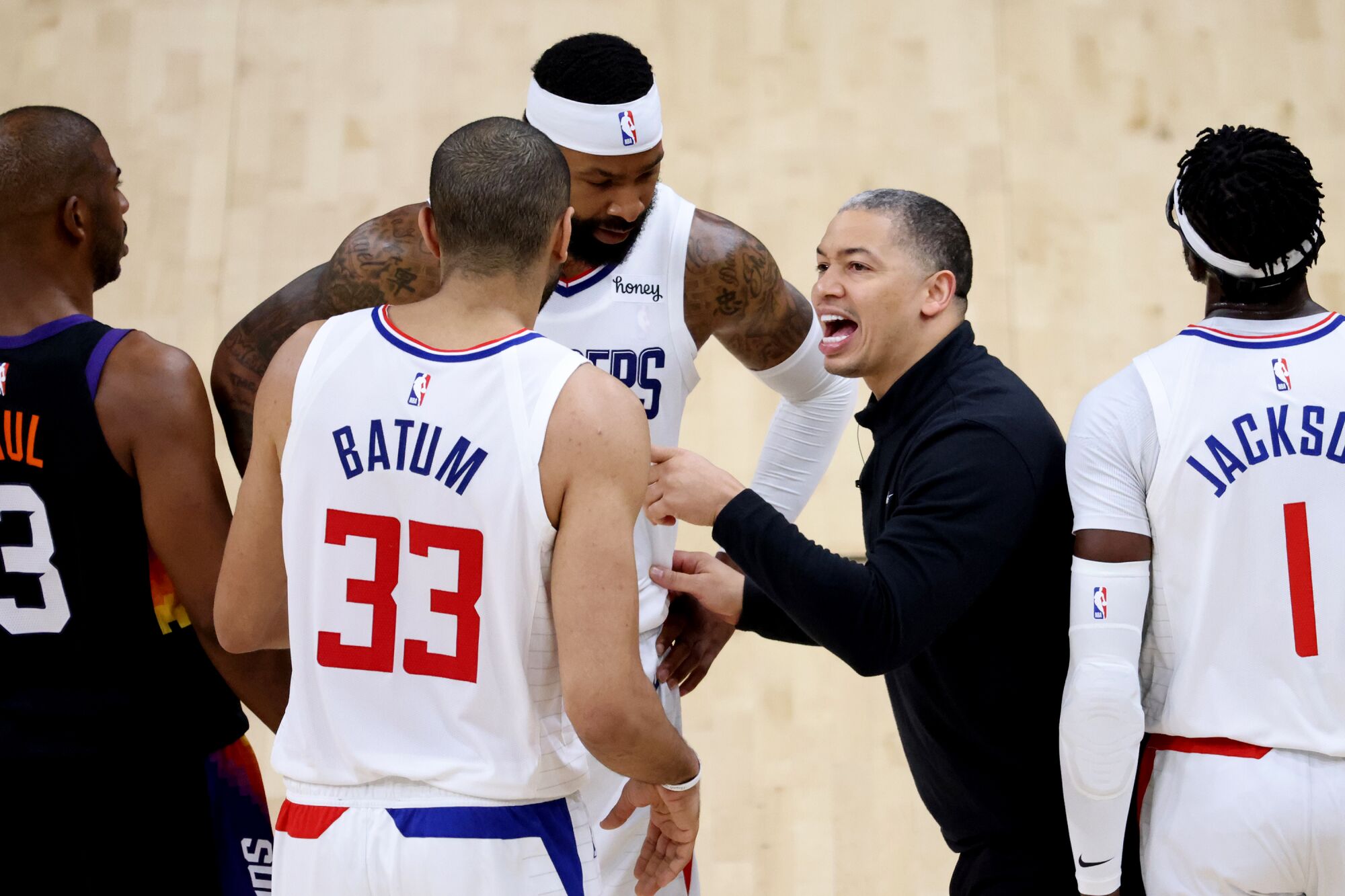 Clippers head coach Tyronn Lue talks strategy with players.