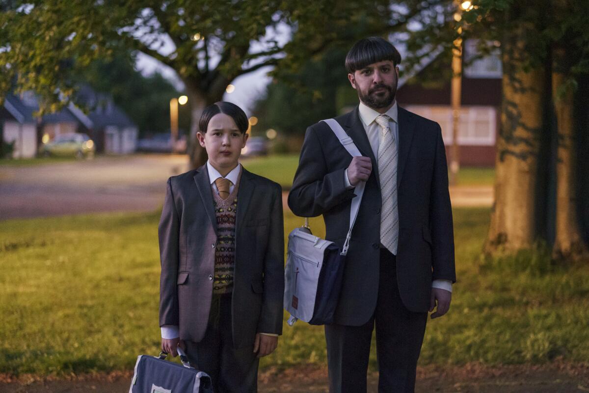 Маленький сын и отец, одетые в костюмы и галстуки