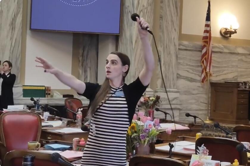 Montana Democratic Rep. Zooey Zephyr hoists a microphone into the air on Monday, April 24, 2023, as her supporters interrupt proceedings in the state House by chanting "Let Her Speak!" in Helena, Mont. Republican leaders in the Legislature didn't let Zephyr, who is transgender, speak on the floor for the third consecutive day because she refuses to apologize for calling GOP lawmakers out for supporting a ban on gender-affirming care. (AP Photo/Amy Beth Hanson)