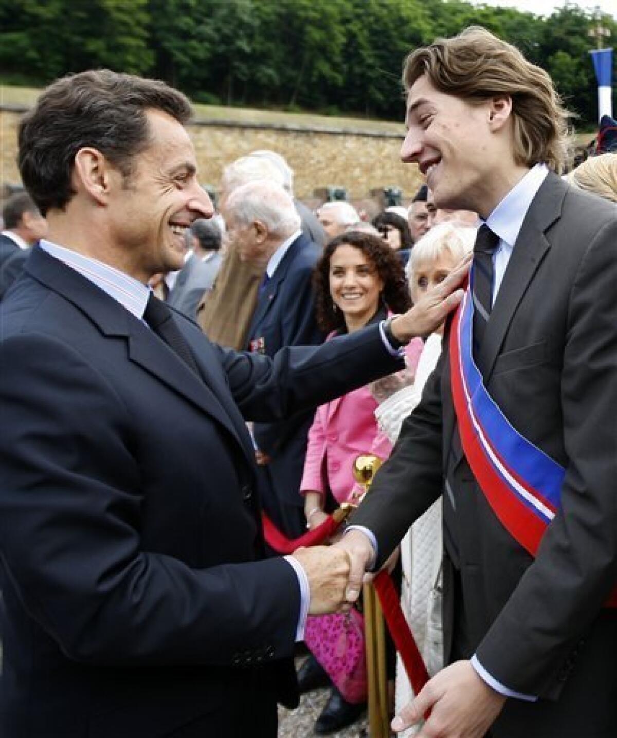 FILE - This June 18, 2009 file photo shows French President Nicolas Sarkozy, left, shaking hands with his son Jean Sarkozy during a commemorative ceremony at the Mont Valerien memorial in Suresnes, west of Paris. Amid fierce accusations of favoritism, President Nicolas Sarkozy's son Jean renounced his candidacy Thursday Oct. 22, 2009 for the leadership of the organization that runs France's most important business district on the western edge of Paris. (AP Photo/Chales Platiau, pool, File)