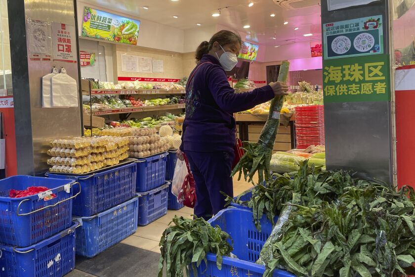 A woman shops in a reopened grocery store in the district of Haizhu as pandemic restrictions are eased in southern China's Guangzhou province, Thursday, Dec. 1, 2022. More Chinese cities eased some anti-virus restrictions as police patrolled their streets to head off protests Thursday while the ruling Communist Party prepared for the high-profile funeral of late leader Jiang Zemin. (AP Photo)