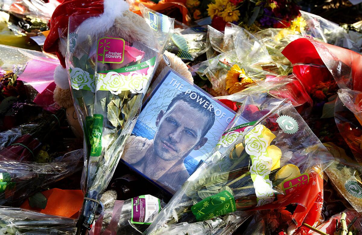 Flowers surround an image of actor Paul Walker at a temporary memorial built where Walker and his friend Roger Rodas were killed in Santa Clarita.