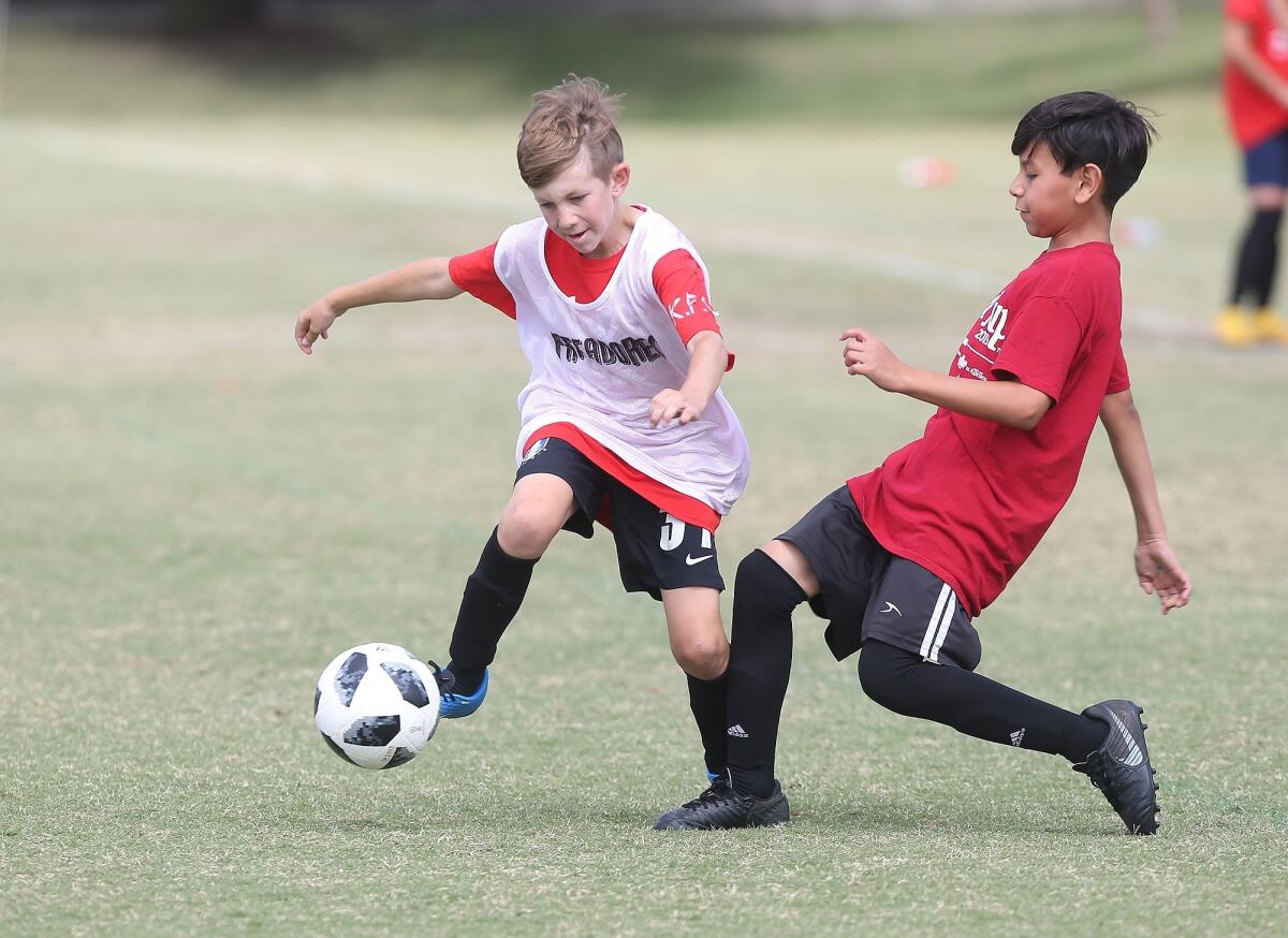 Kaiser Elementary's Cameron Deisner, left, battles Adams' Romeo Flores in a boys’ fifth and sixth-grade Silver Division pool-play match at the Daily Pilot Cup on Friday at Jack R. Hammett Sports Complex in Costa Mesa.