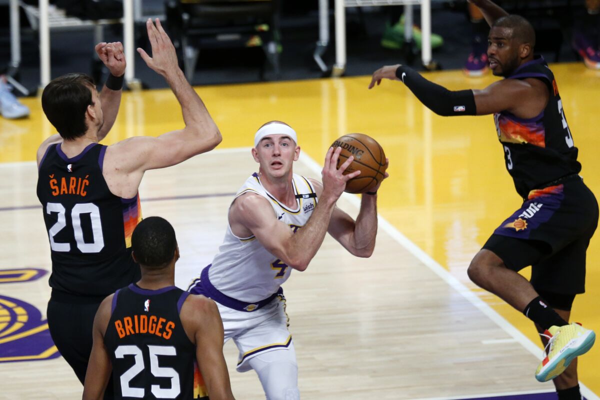 Lakers guard Alex Caruso is surrounded by Suns defenders after driving into the lane.