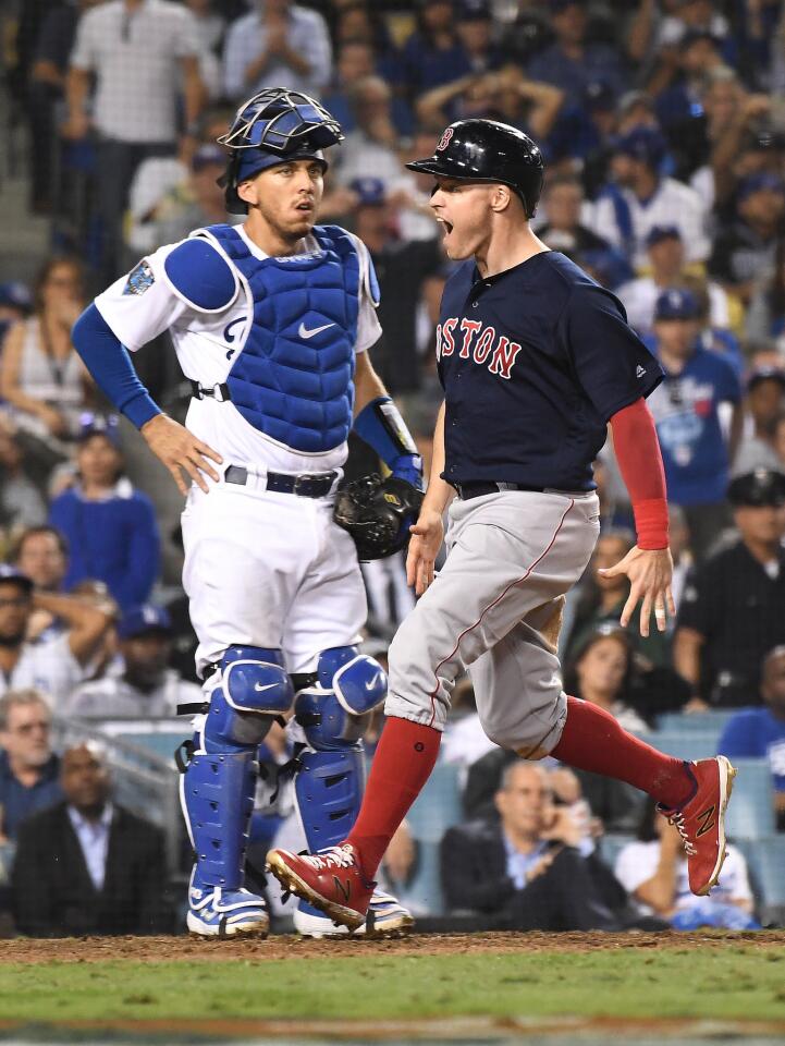 As Dodger catcher Austin Barnes watches, Red Sox Brock Holt scores the go-ahead run the 13th inning.