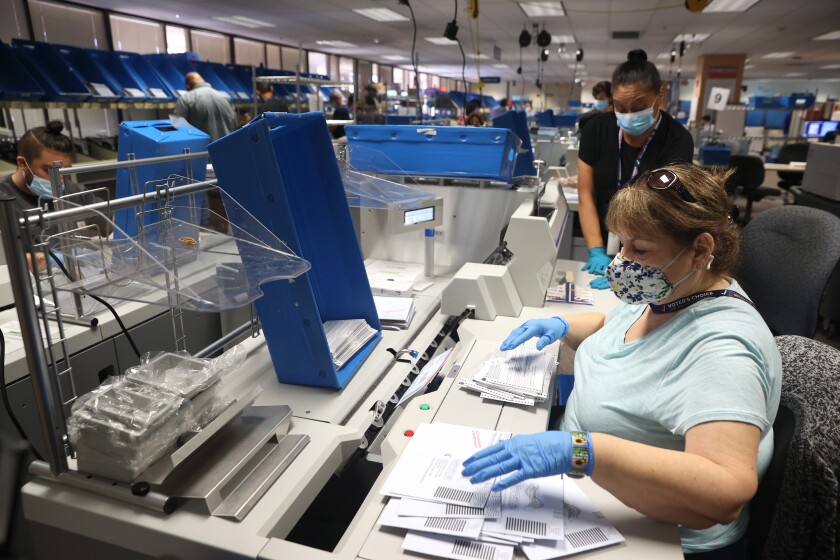 Workers sort through mail-in ballots at the Santa Clara County Registrar of Voters office.