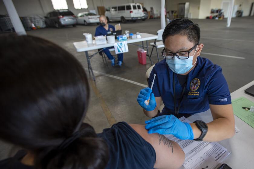GARDENA, CA - APRIL 17: Registered nurse Justine Bertulano, right, gives Yolanda Estrada-Saporito, left, of Garden Grove, her second Moderna vaccination on Saturday, April 17, 2021 in Gardena, CA. It was very quiet at the time she received her dose she was the only patient. There were 38 people who received their vaccination here today. VA Long Beach, in collaboration with the Dae Hueng Presbyterian Church of Gardena, hosted a vaccination event for veterans, their spouses and caregivers. It'll be the first of two events to give out both doses of the Moderna Vaccine. It's also the first time the VA is vaccinating spouses and caregivers. (Francine Orr / Los Angeles )
