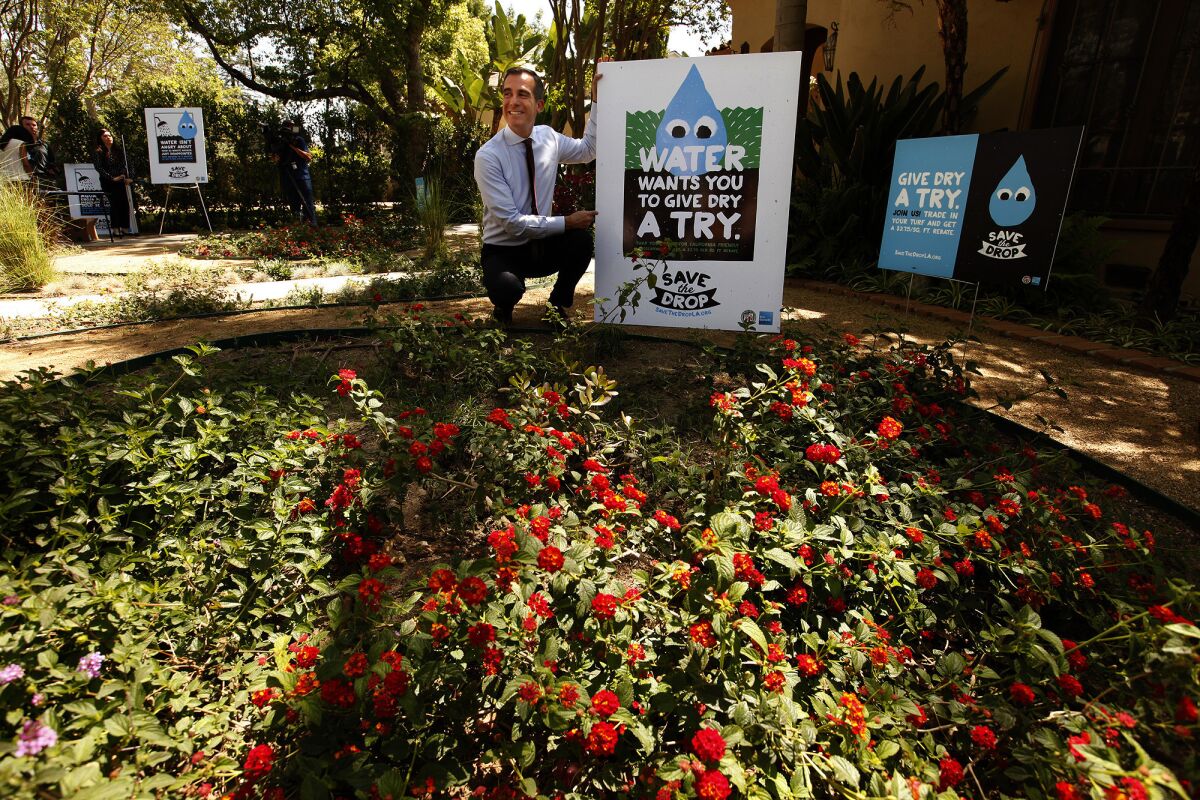 Los Angeles Mayor Eric Garcetti poses with signage for his "Save the Drop" campaign after talking about the program to connect Angelenos with water conservation tools in Van Nuys on April 9.