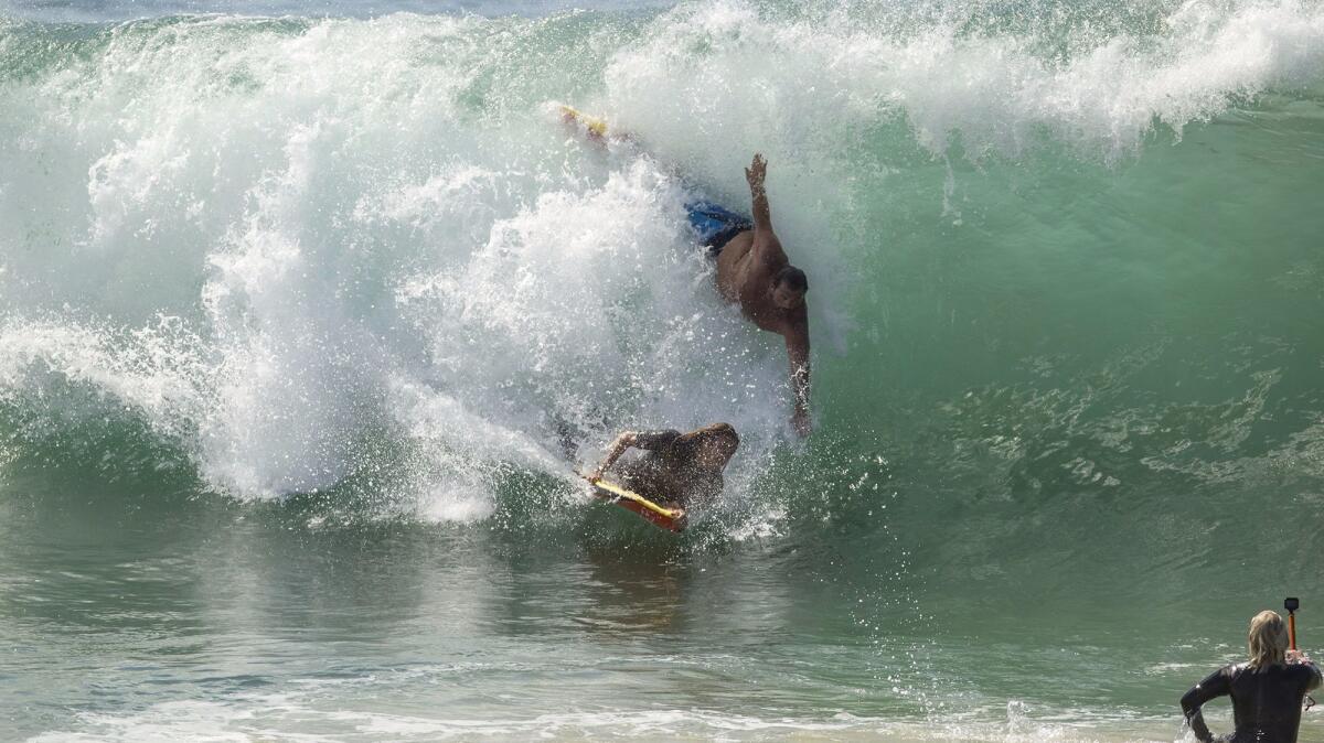 A bodysurfer and a bodyboarder catch the same wave Tuesday morning at the Wedge in Newport Beach. (Kevin Chang / Daily Pilot)