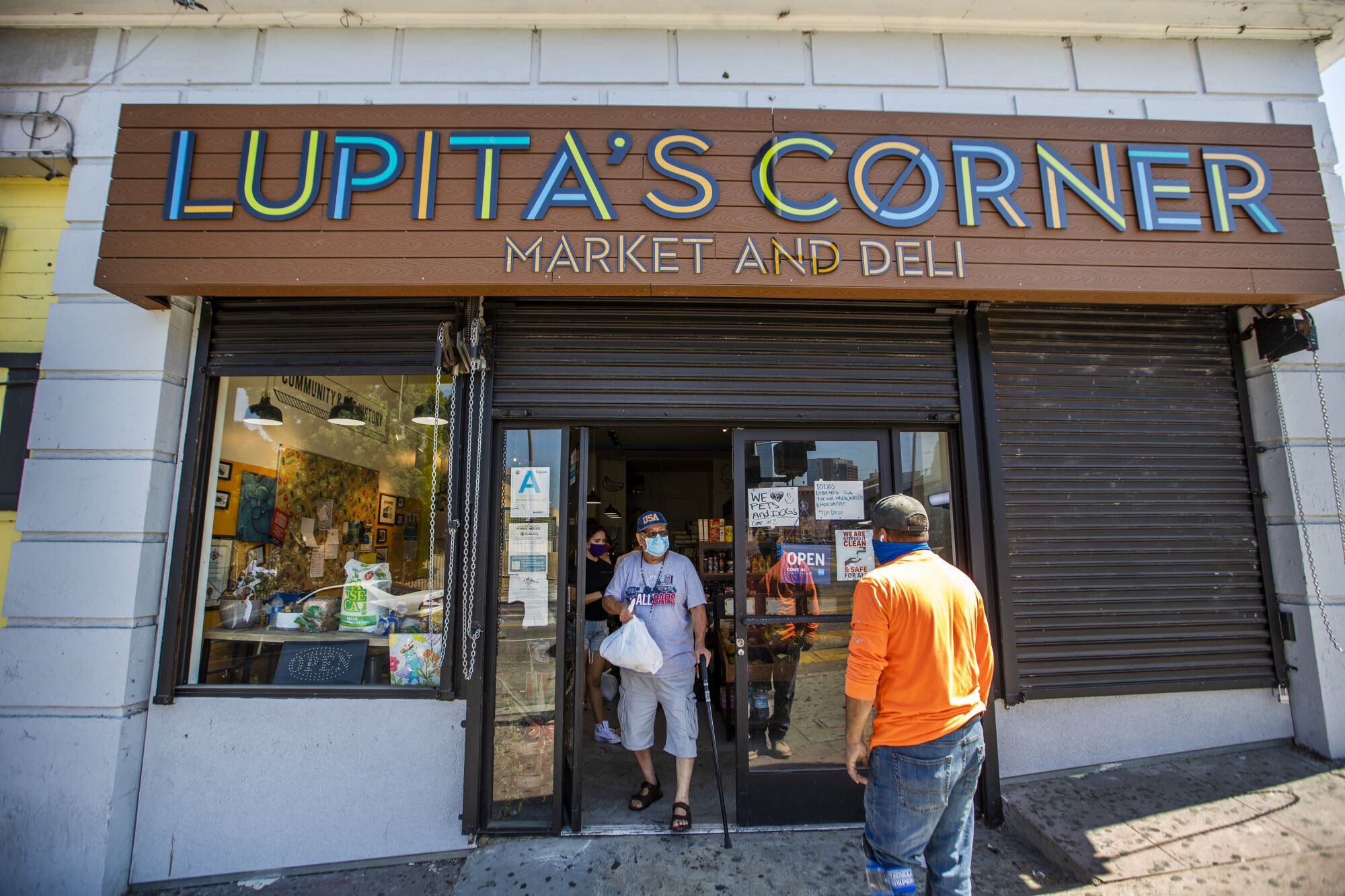 A neighborhood resident receives donated groceries at Lupita's market. 