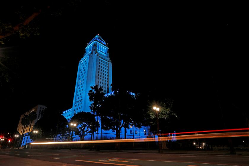 LOS ANGELES, CA -- APRIL 10: Los Angeles City Hall in downtown displays blue lights to show support for health care workers and first responders on the front lines against the coronavirus pandemic on Friday, April 10, 2020, in Los Angeles, CA. (Gary Coronado / Los Angeles Times)