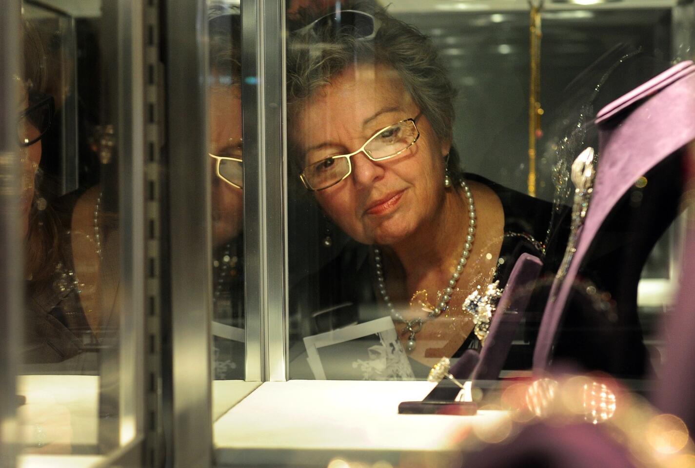 A woman views jewelry on display during a press preview.