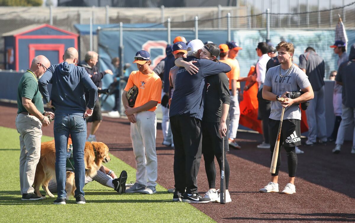 Members of the Orange Coast College baseball team gather at the field before Monday's practice, a day after head coach John Altobelli died with his wife, Keri, and 14-year-old daughter Alyssa in Sunday's helicopter crash in Calabasas.
