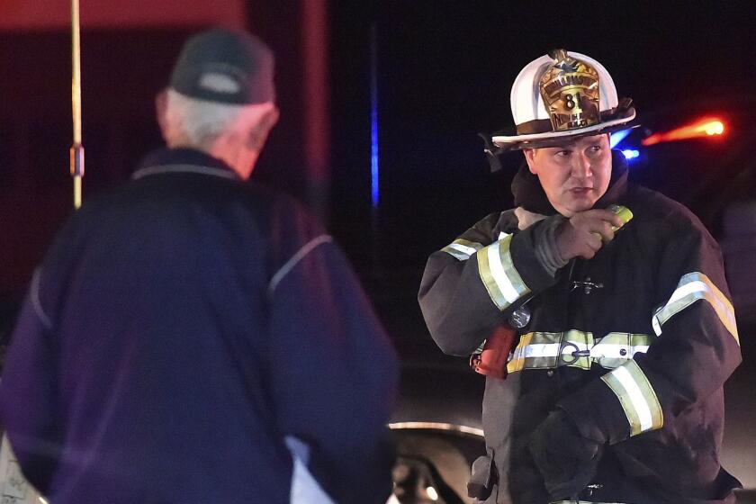 One of the first responders work the scene of an explosion and reported stand-off in North Haven, Conn., Wednesday, May 2, 2018. A barn behind a house in Connecticut exploded Wednesday night while police and a SWAT team were negotiating with a man who had taken his wife and family hostage, leaving several officers injured, officials said. (Catherine Avalone/New Haven Register via AP)