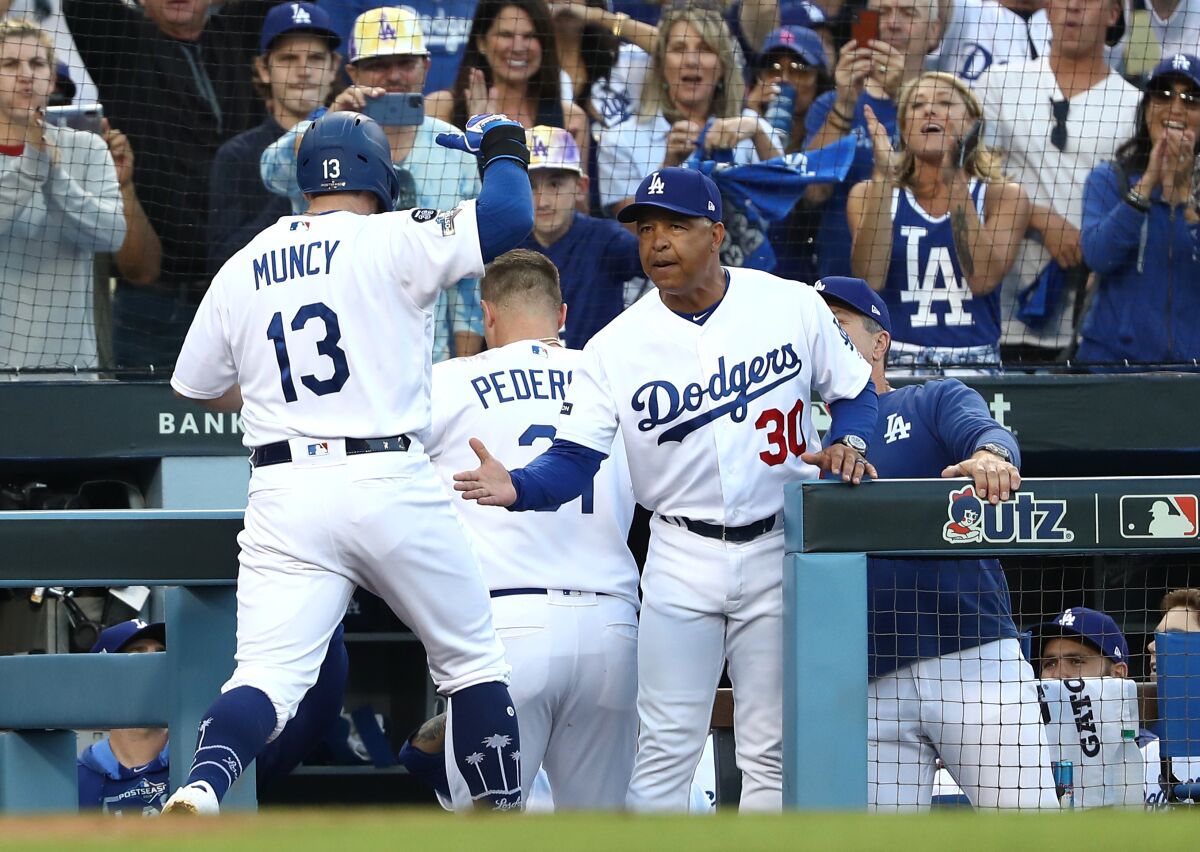 Dodgers manager Dave Roberts, left, congratulates Max Muncy on his two-run home run against the Nationals in Game 5 of the NLDS.
