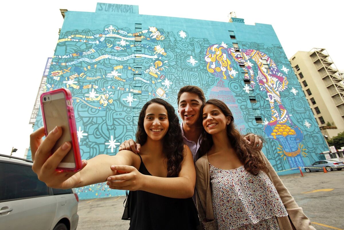 Now you can put an image of yourself on a piece of toast with a selfie toaster. Above, visitors from Mexico take a traditional selfie in front of a mural in downtown L.A.