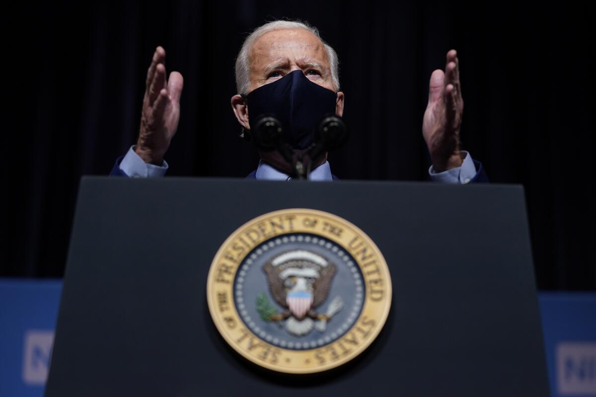 President Biden gestures while speaking at a lectern