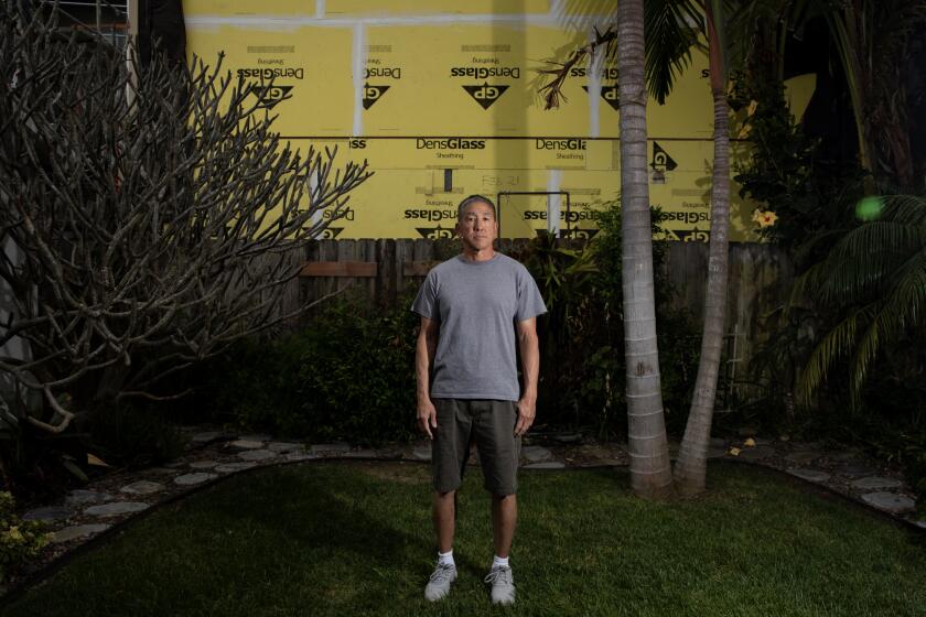 San Diego, California - May 02: Marc Umemoto stands in his backyard, behind him is his neighbor's property where an accessory dwelling unit is being built in Crown Point on Thursday, May 2, 2024 in San Diego, California. (Ana Ramirez / The San Diego Union-Tribune)