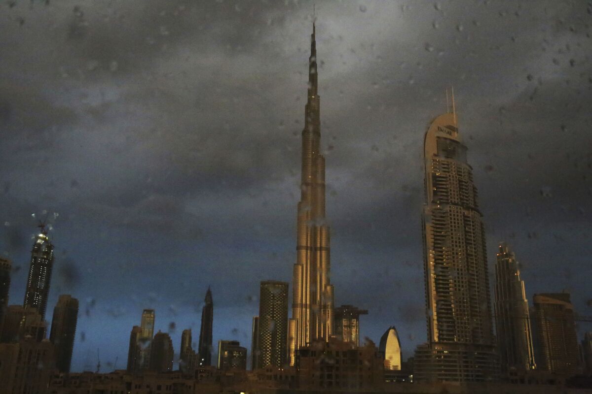 FILE - In this Nov. 26, 2018 file photo, sunlight reflects off the Burj Khalifa, the world's tallest building, during a rain shower in Dubai, United Arab Emirates. For eager Israelis, anticipation is mounting that Dubai’s glitzy Burj Khalifa, will soon join the ranks of the Pyramids in Egypt and relics of the ancient Nabatean Kingdom of Petra in Jordan as an iconic landmark that was once unattainable but is now within reach. Last week’s dramatic announcement making the UAE just the third Arab nation to establish full diplomatic ties with Israel has set off a flurry of excitement. (AP Photo/Jon Gambrell, File)