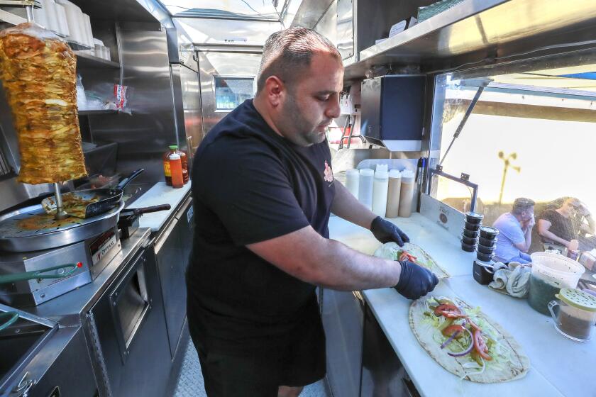 Bryan Zeto, owner and chef of the Shawarma Guys food truck, prepares a chicken and a beef shawarma pita in South Park on Saturday, January 4, 2020 in San Diego, California.