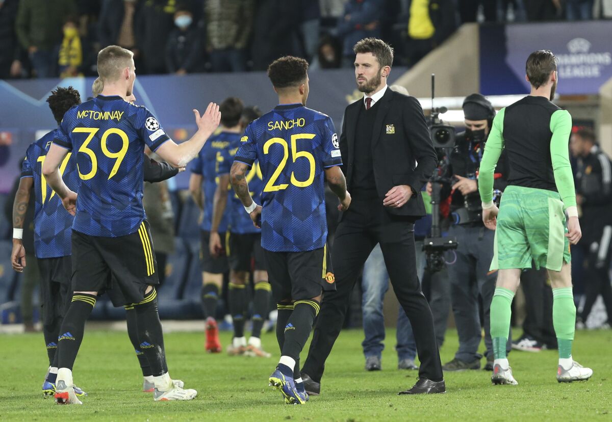 Manchester United's caretaker manager Michael Carrick, 3rd left, shakes hands with Manchester United's Jadon Sancho and Scott McTominay at the end of a Group F Champions League soccer match between Villarreal and Manchester United at the Ceramica stadium in Villarreal, Spain, Tuesday, Nov. 23, 2021. (AP Photo/Alberto Saiz)