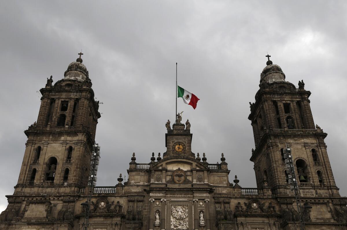 ARCHIVO - La bandera nacional de México ondea a media asta en la parte superior de la Catedral 