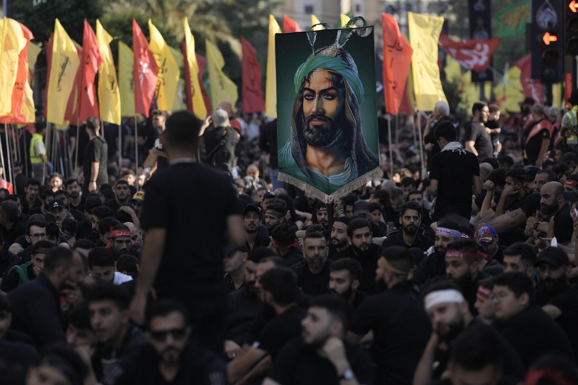 Supporters of Hezbollah hold a picture depicting the prophet Muhammad's grandson Imam Hussein in Beirut.